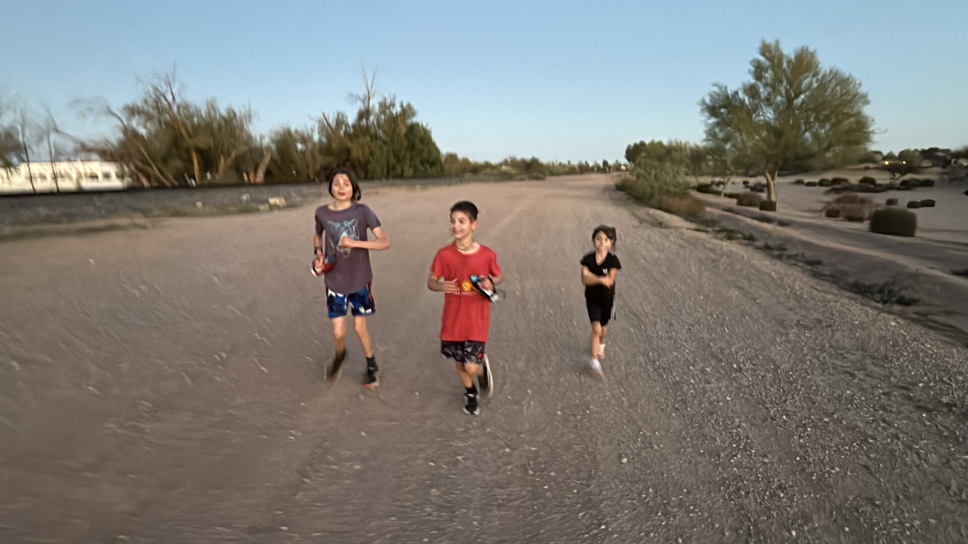 All three kids running together through the Arizona desert — mile 14